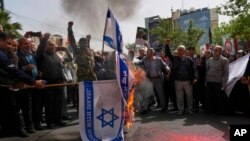 Protestuesit iranianë duke djegur flamujt izraelitë gjatë një proteste të mbajtur në Teheran, në prill të këtij viti.