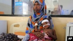 O femeie somaleză își îngrijește copilul la Spitalul Banadir din Mogadishu, Somalia, miercuri, 14 mai 2025. (AP Photo/Farah Abdi Warsameh)