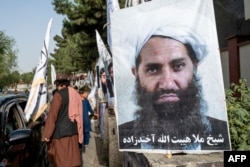 Un poster al liderului suprem al talibanilor, Hibatullah Akhundzada, lângă un drum din Kabul, în august 2023.