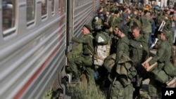 Russian military recruits board a train in the Volgograd region to fight in Ukraine. With greater manpower and resources at its disposal, will Moscow eventually grind out a victory against Kyiv in a protracted conflict? 