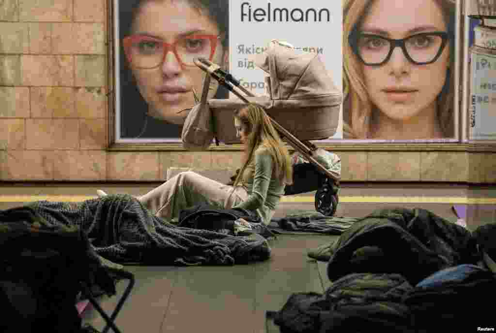 Një grua duke qëndruar pranë një karroce për foshnje, gjatë një sulmi rus me dronë dhe raketa në Kiev, më 12 korrik.