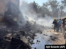 Pompierii la locul prăbușirii unui avion în orașul Ahmedabad din nord-vestul Indiei, în statul Gujarat, joi, 12 iunie 2025