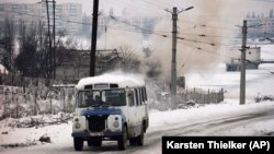 Автобус їде дорогою у Чечні на тлі обстрілів у Грозному, 24 січня 1995 року