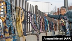 Një burrë vendos kravata për kryeministrin Haradinaj. Qytetarët, duke dhuruar kravata dhe këmisha kishin kundërshtuar vendimin e Haradinajt për rritjen e pagave. 