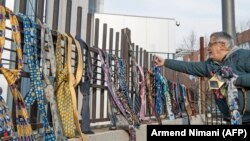 Një burrë vendos kravata për kryeministrin Haradinaj. Qytetarët, duke dhuruar kravata dhe këmisha kishin kundërshtuar vendimin e Haradinajt për rritjen e pagave.