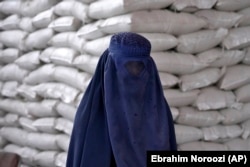 An Afghan woman waits to receive a food ration in Kabul in May 2022.