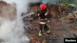 Vatrogasac pored zgrade uništene u ruskom napadu drona u gradu Priluki, Černihivska oblast, Ukrajina, 5. juni 2025.