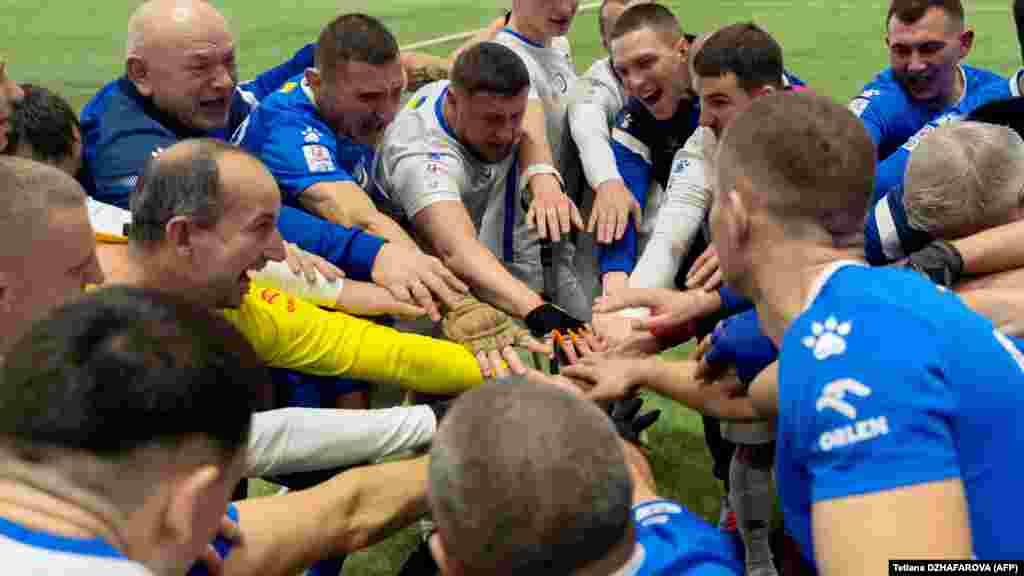 A két csapat játékosai üdvözlik egymást a meccs után a Dinamo Kijev végtaghiányos focitornáján Kijevben