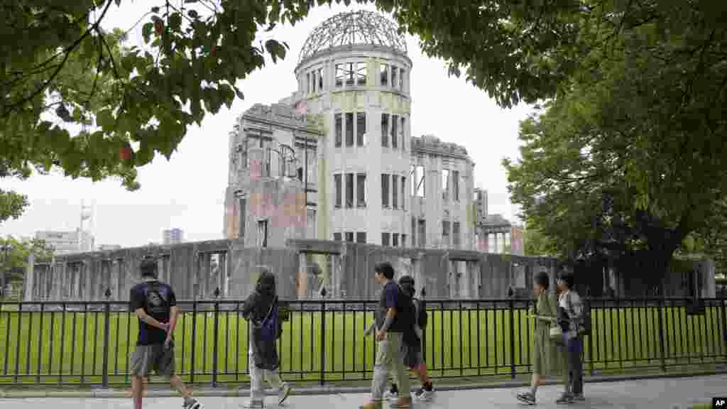 Turisták az Atombomba-dóm előtt 2025. július 9-én Hirosimában. Az épületet meghagyták a robbanás utáni állapotában, mementóként a következő nemzedékek számára