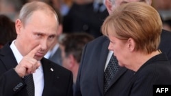 Президент России Владимир Путин беседует с канцлером Германии Ангелой Меркель вскоре после аннексии Крыма. Нормандия, 6 июня 2014 года.