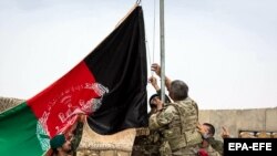 Авганистански и американски војници го креваат знамето на Авганистан на церемонија за прослава на Денот на авганистанската армија.