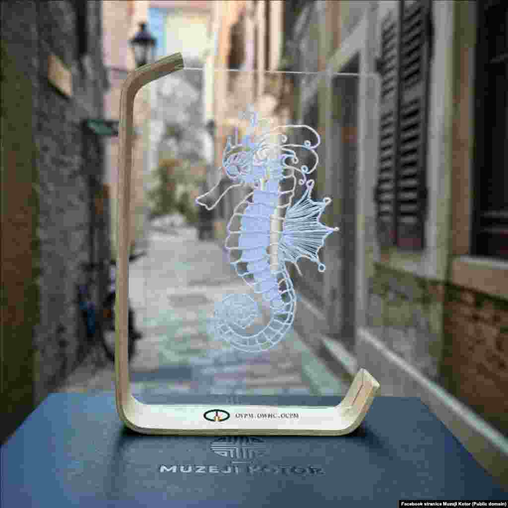 Suvenir od dobrotske čipke sa motivom morskog konjića. U Jadranskom moru žive dvije vrste morskih konjića, koje su zbog ugroženosti zaštićene međunarodnim konvencijama.