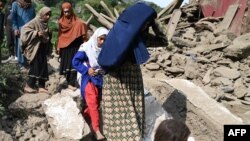 Afganistanke pored oštećene kuće nakon zemljotresa u selu Mazar Dara u okrugu Nurgal u istočnom Afganistanu, 1. septembra 2025. godine.