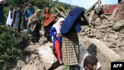 Авганистанки покрај оштетена куќа по земјотресот во селото Мазар Дара во округот Нургал, источен Авганистан, 1 септември 2025 година.