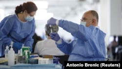 Medicinski radnik priprema injekciju s dozom cjepiva AstraZeneca protiv COVID-19, u centru za cijepljenje u dvorani Zagrebačkog velesajma, 7. travnja 2021.