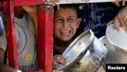 Palestinieni adunați să ceară mâncare unei organizații umanitare, în Gaza City, la 22 iulie 2025. ONU spune că peste 1000 dintre ei au murit în incidente legate de căutarea hranei în ultimele două luni. 