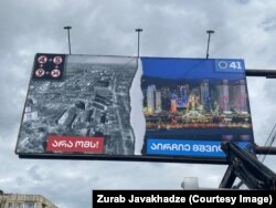 A kormányzó Georgiai Álom óriásplakátja Tbiliszi belvárosában. A bal oldali kép alatt a Nemet a háborúra! felirat olvasható, míg a jobb oldalinál a következő szöveg: Válaszd a békét!