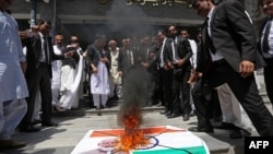 Lawyers burn a banner with a picture of India's national flag and Prime Minister Narendra Modi during an anti-India protest in Multan, Pakistan, on April 28.