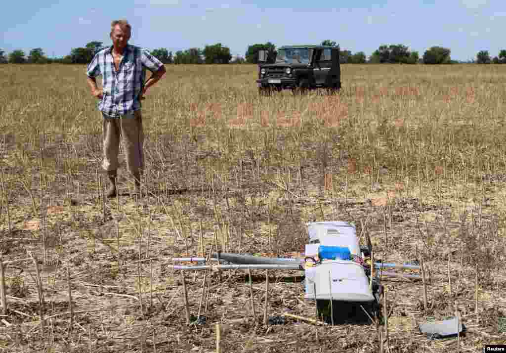 Фермер осматривает российский боевой дрон, который упал на его поле во время российского нападения на Украину, в Херсонской области, Украина, 24 июля 2025 года. REUTERS/Иван Антипенко