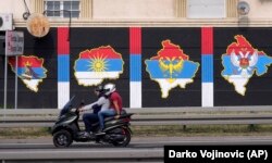 Dy persona shihen në një motoçikletë, e cila ka mbrapa hartat e Kosovës, Maqedonisë së Veriut, Bosnje-Hercegovinës dhe Malit të Zi, me flamuj të Serbisë në to. Beograd, gusht 2021.