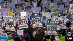 Demonstranți în fața Capitoliului de Stat din Minnesota în timpul protestului național „Hands Off!” împotriva președintelui american Donald Trump și a consilierului său, CEO-ul Tesla - Elon Musk, în St. Paul, Minnesota, pe 5 aprilie 2025.
