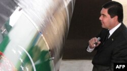 Президент Туркменистана Гурбангулы Бердымухаммедов ставит автограф на трубопроводе на церемонии его открытия. Шатлык, 31 мая 2010 года.