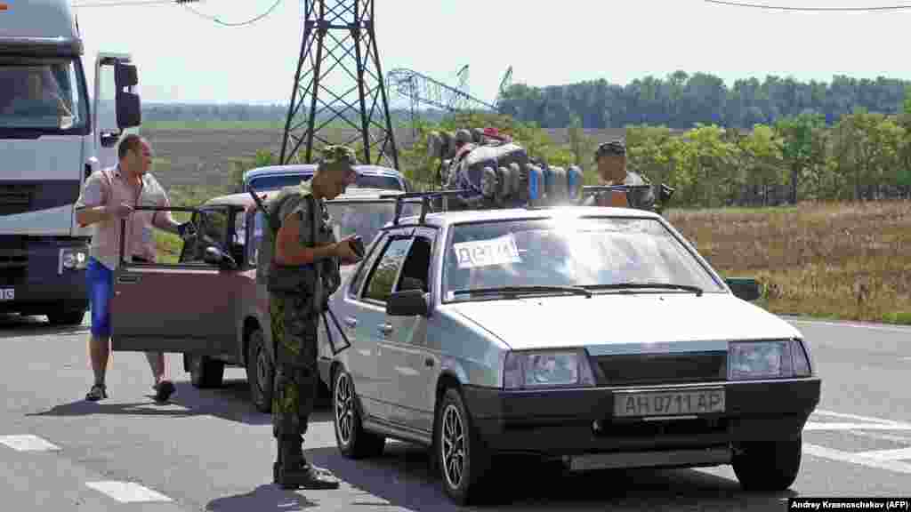 Ukrán katona ellenőrzi a dokumentumokat egy ellenőrző ponton Marjinka közelében 2014 augusztusában