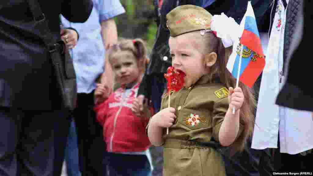 A young Crimean girl wears military-type clothes during a Victory Day celebration in Sevastopol on May 9, 2018.