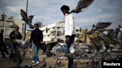 Архивска фотографија: Африкански мигранти ранат голуби во паркот Левински во Тел Авив на 9 јануари 2014 година
