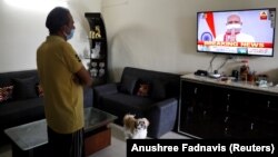 Stanovnik Nju Delhija gleda obraćanje premijera Indije Narendre Modija o produženju mjera zabrane do 3. maja