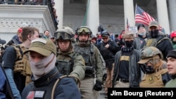 Szélsőjobboldali rendbontókat kísérnek le a Capitolium lépcsőjén Washingtonban 2021. január 6-án