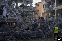 Forțele de securitate israeliene inspectează clădirile rezidențiale distruse care au fost lovite de o rachetă lansată din Iran asupra orașului Ramat Gan, lângă Tel Aviv, Israel. Sâmbătă, 14 iunie 2025.