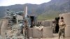 FILE: Afghan soldiers inspect their checkpost damaged in a militant attack in Kunar.