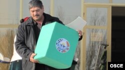 Член избирательной комиссии в Бухаре с выносной урной для избирателей. 27 декабря 2009 года.