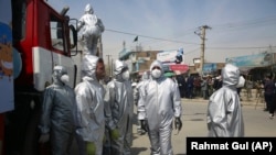 Volunteers in protective suits disinfect public areas in the capital Kabul to help in curbing the spread of the coronavirus infections on April 8.