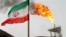 A gas flare on an oil production platform in the Soroush oil fields is seen alongside an Iranian flag in the Gulf 