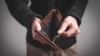 Man holding empty wallet. No money