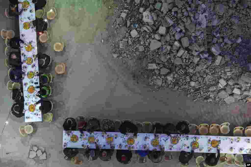 Banorë të mbledhur për iftarin e organizuar nga Fondacioni Turk Humanitar Relief (IHH), në ditën e parë të muajit të Ramazanit në lagjen Jobar, e cila u shkatërrua nga lufta siriane, në Damask, Siri, të shtunën, më 1 mars 2025.