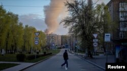 Një burrë kalon një rrugë pranë vendit të një sulmi me dronë rusë në Kiev, më 12 prill.