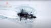 Un submarin nuclear sparge gheața arctică în timpul unui exercițiu militar; 26 martie 2021.