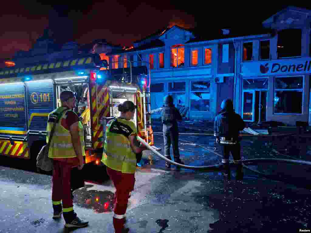 Pompierii încearcă să stingă incendiul care s-a extins și asupra altor spații comerciale. 