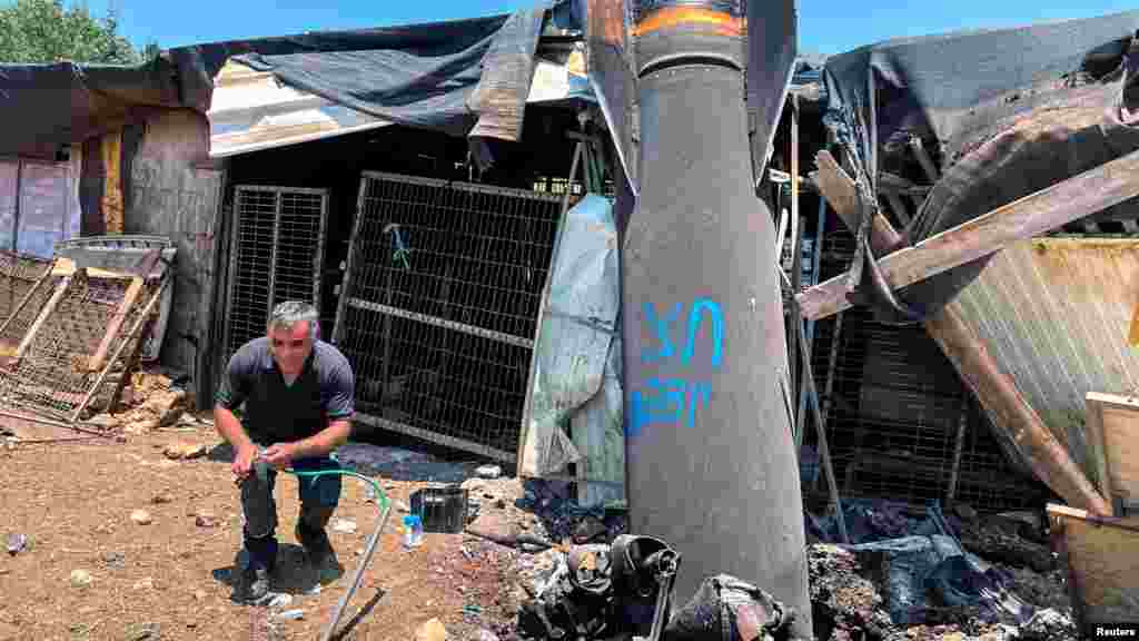 Muškarac pozira pored ostataka balističke rakete nakon vazdušnog napada Irana na severni Izrael.