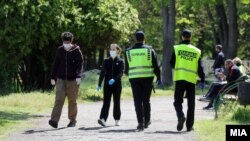 Архивска фотограгија- Луѓе со заштитни маски и полиција во Градски парк во Скопје