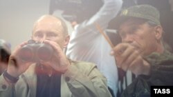 Президент России Владимир Путин с биноклем. Учения «Кавказ-2012» на полигоне «Раевский». 17 сентября 2012 года.
