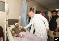 Fotografie distribuită de Ministerul indian de Interne - ministrul de Interne se întâlnește cu supraviețuitorul accidentului aviatic, britanicul Vishwash Kumar Ramesh, 40 de ani, la un spital din Ahmedabad.