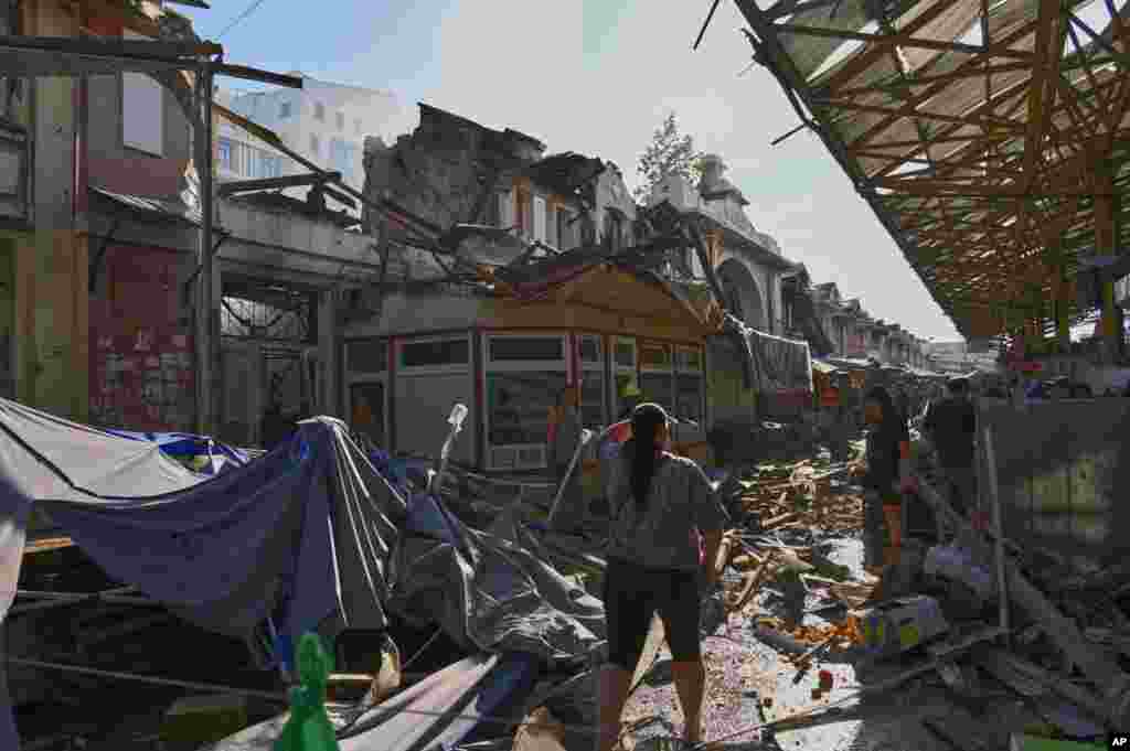 O femeie privește ruinele pieței în urma atacului rusesc.