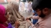 A health worker administers polio vaccine to children during a three-day countrywide vaccination campaign in Peshawar on August 26.