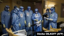 Orvosok védőruhában egy moszkvai kórház koronavírusos betegeket ápoló intenzív osztályán 2021. október 20-án