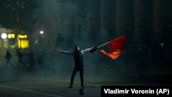 Участник протеста размахивает флагом в Бишкеке. 6 октября 2020 года.