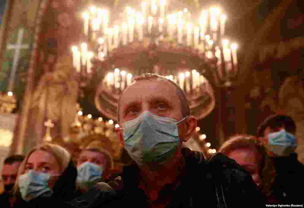 Vjernici sa maskama tokom božićne mise u Katedrali Svetog Vladimira u Kijevu.